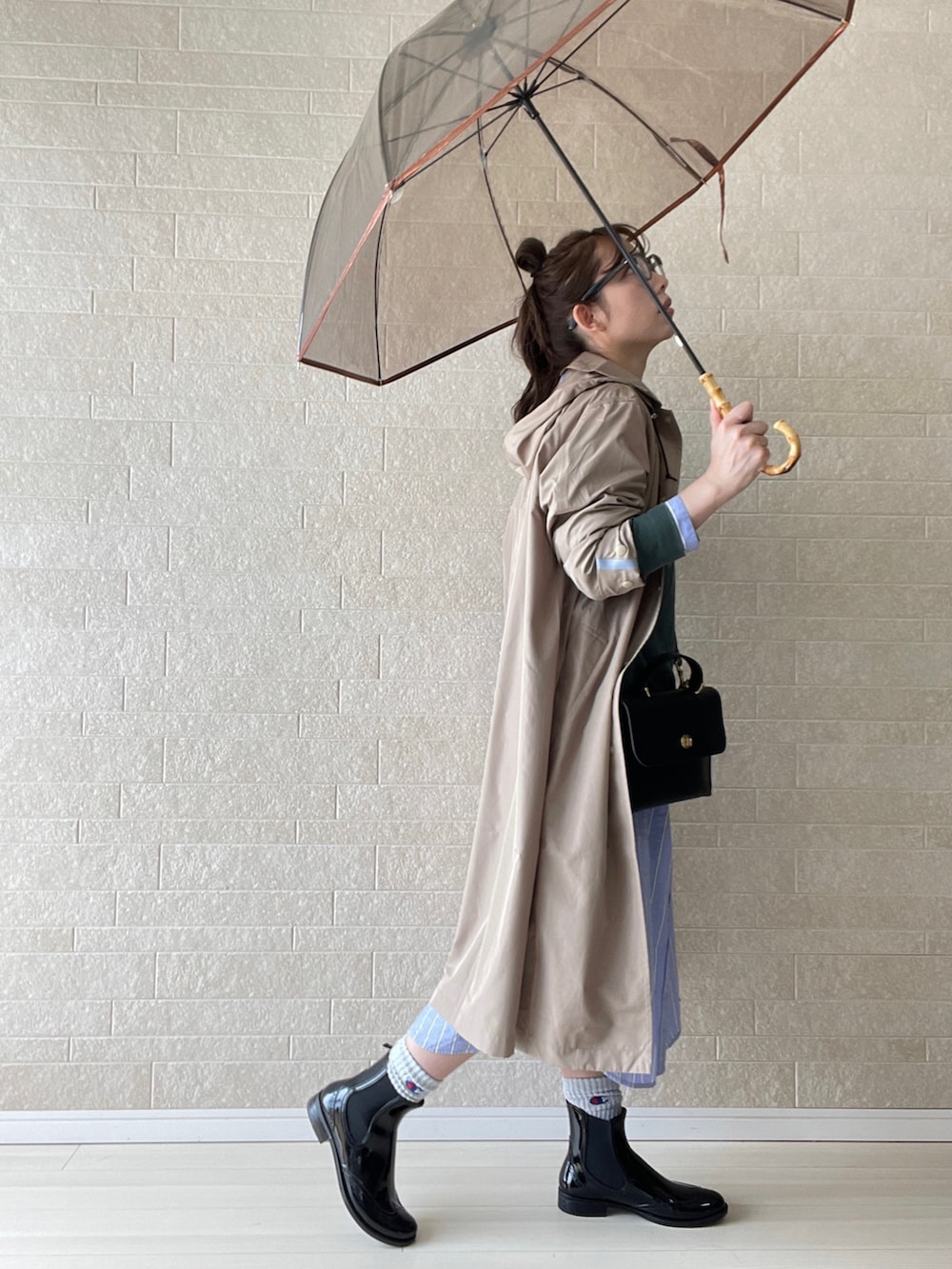 ブラック系のレインシューズ、ブラック系のショルダーバッグ、ブルー系のシャツワンピースを着用したレディースの春コーディネートの3枚目の写真