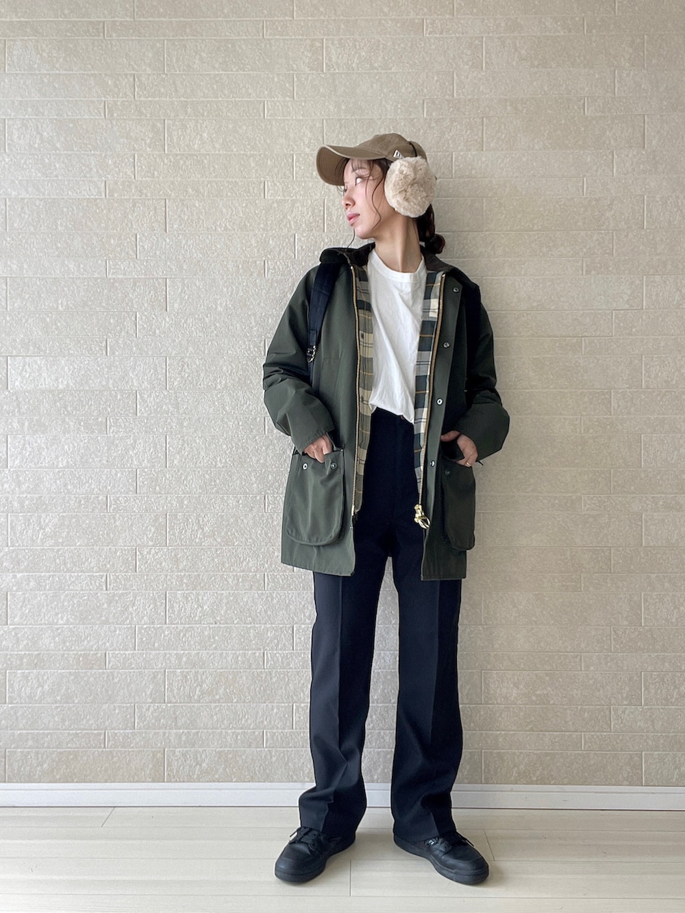 ブラック系のスラックス、グリーン系のブルゾン、ブラック系のスニーカーを着用したレディースの秋コーディネートの3枚目の写真