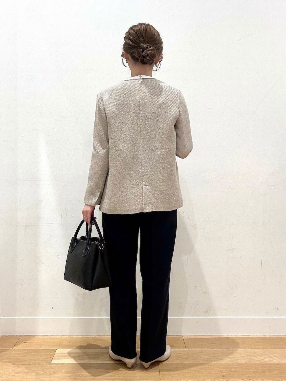 ブラック系のショルダーバッグ、ベージュ系のベスト、グレー系のスーツジャケットを着用したレディースの春コーディネートの6枚目の写真