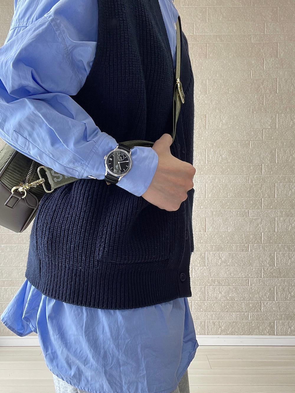 グリーン系のショルダーバッグ、グレー系のスウェットパンツ、ホワイト系のスニーカーを着用したレディースの冬コーディネートの5枚目の写真