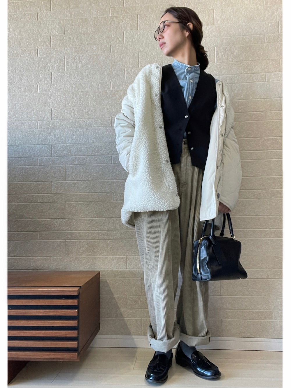 ホワイト系のブルゾン、ベージュ系のパンツ、ブラック系のローファーを着用したレディースの冬コーディネートの2枚目の写真