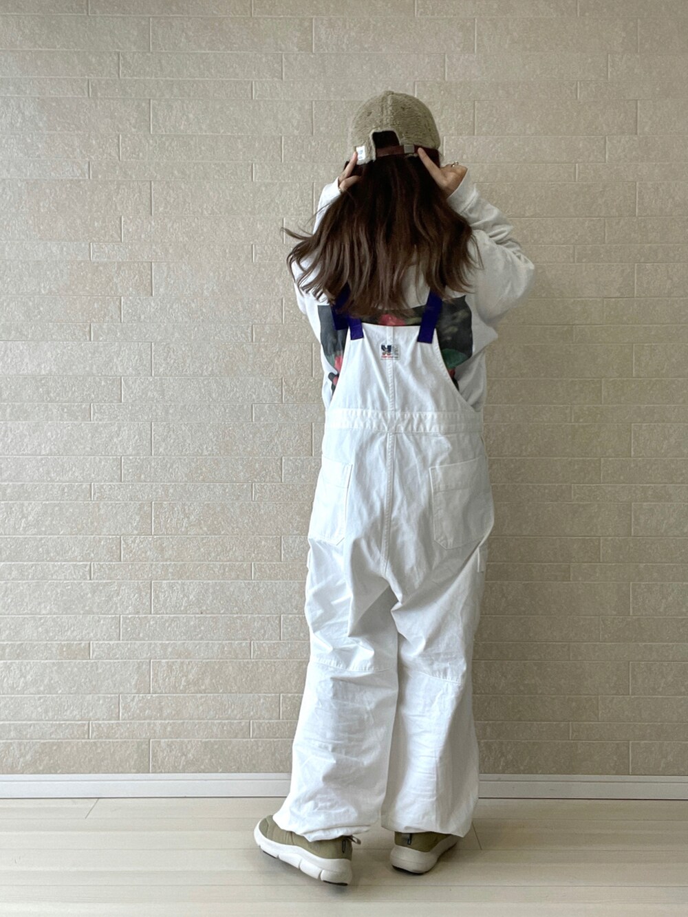 ホワイト系のサロペット/オーバーオール、ベージュ系のスニーカー、ブラック系のジャケット/アウターを着用したレディースの秋コーディネートの4枚目の写真