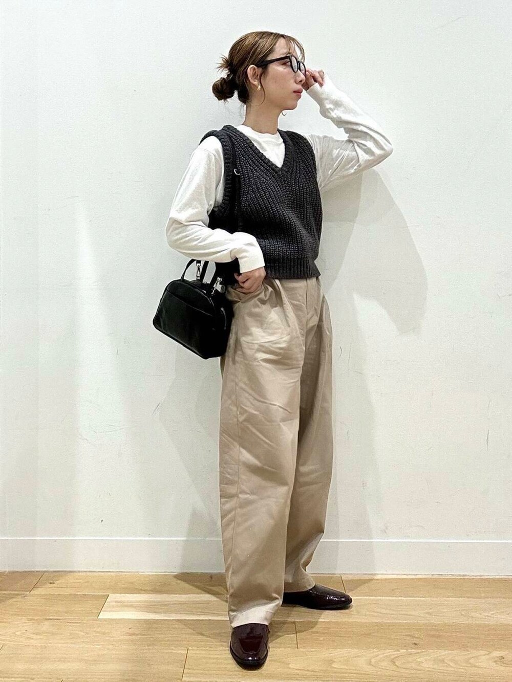 レッド系のローファー、ホワイト系のTシャツ/カットソー、グレー系のベストを着用したレディースの秋コーディネートの2枚目の写真