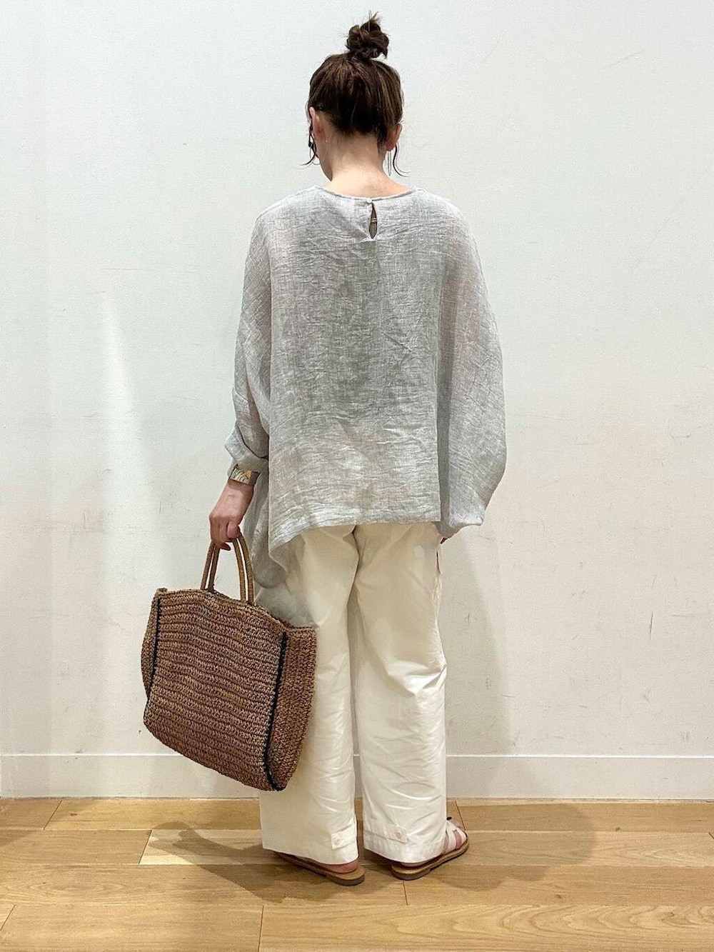 ベージュ系のトートバッグ、ホワイト系のサンダル、ベージュ系のタンクトップを着用したレディースの春コーディネートの4枚目の写真