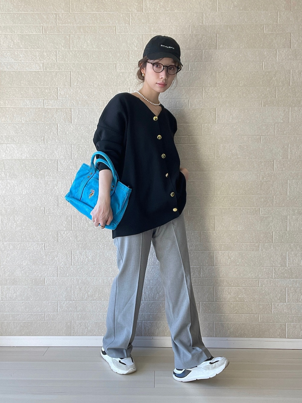 ブルー系のトートバッグ、グレー系のスラックス、ホワイト系のスニーカーを着用したレディースの冬コーディネートの2枚目の写真