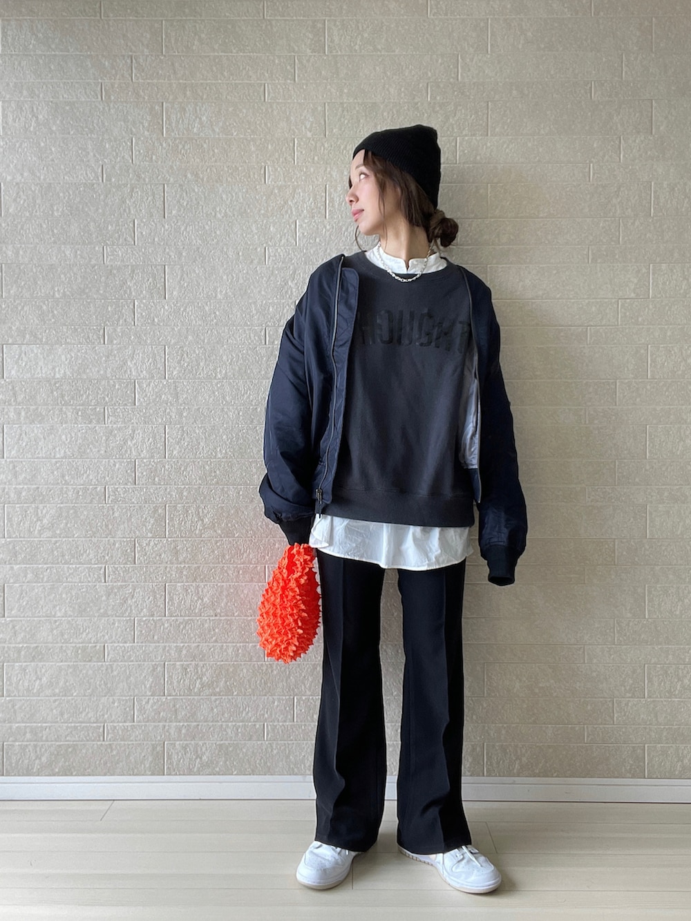 ブラック系のその他パンツ、オレンジ系のエコバッグ/サブバッグ、ホワイト系のスニーカーを着用したレディースの秋コーディネートの2枚目の写真