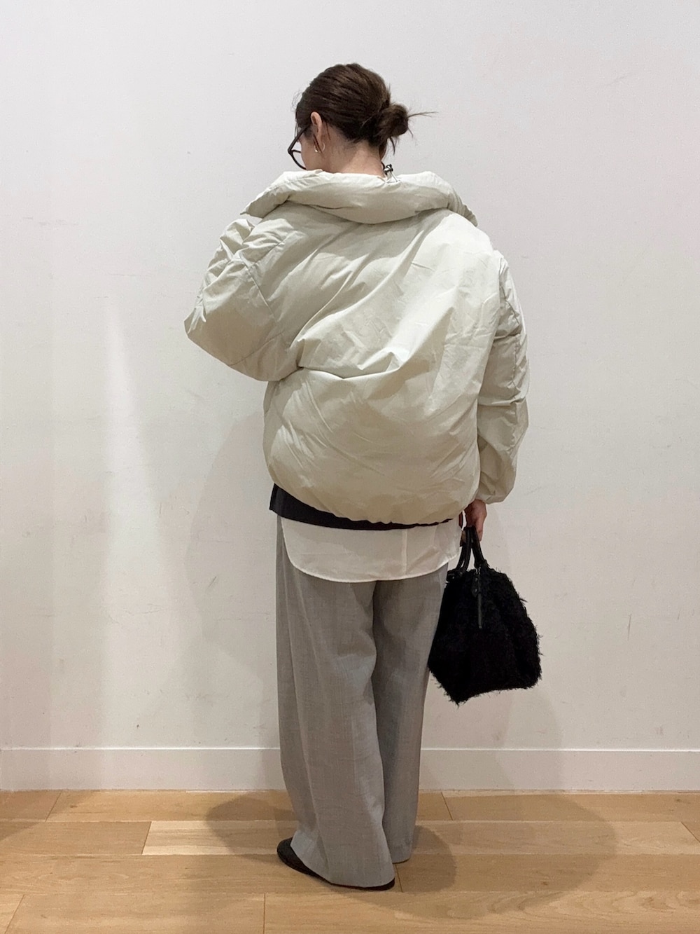 グレー系のニット/セーター、ホワイト系のダウンジャケット/コート、ブラック系のハンドバッグを着用したレディースの秋コーディネートの6枚目の写真