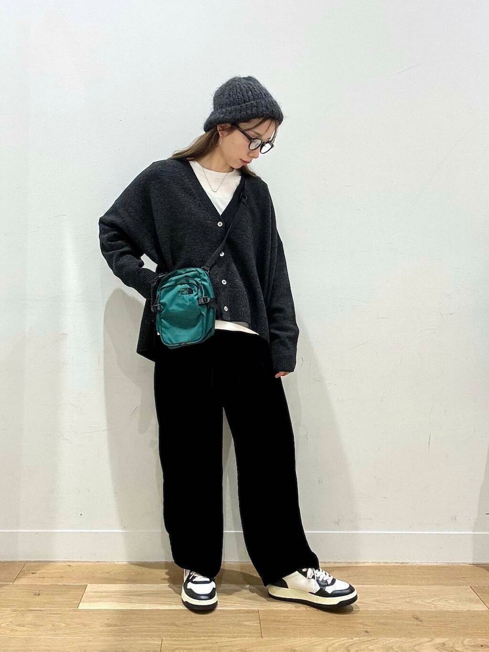 ブラック系のその他パンツ、ホワイト系のTシャツ/カットソー、グレー系のニット/セーターを着用したレディースの冬コーディネートの4枚目の写真