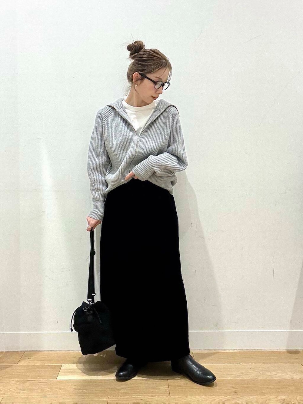 ブラック系のブーツ、グレー系のカーディガン/ボレロ、ブラック系のスカートを着用したレディースの冬コーディネートの5枚目の写真