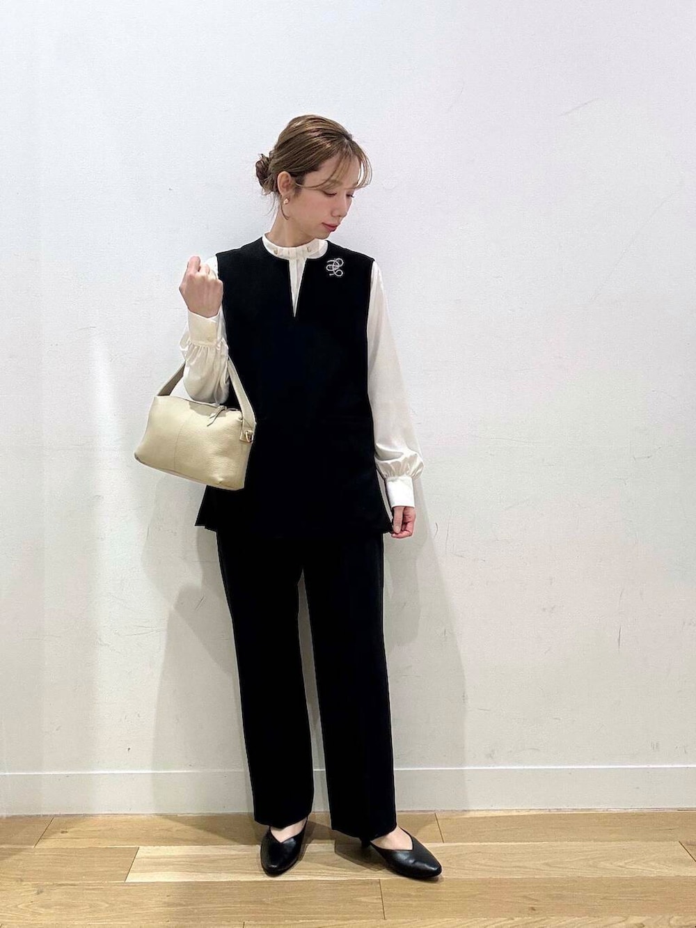 ホワイト系のショルダーバッグ、ブラック系のベスト、ホワイト系のシャツ/ブラウスを着用したレディースの冬コーディネートの4枚目の写真