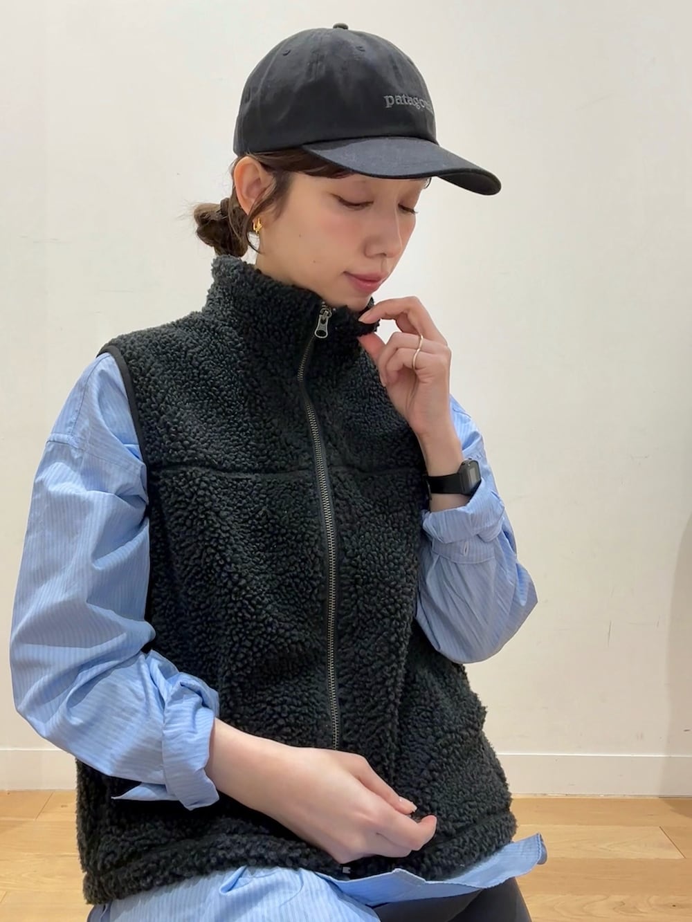 グレー系のベスト、ブラック系のダウンジャケット/コート、ブルー系のシャツ/ブラウスを着用したレディースの冬コーディネートの6枚目の写真