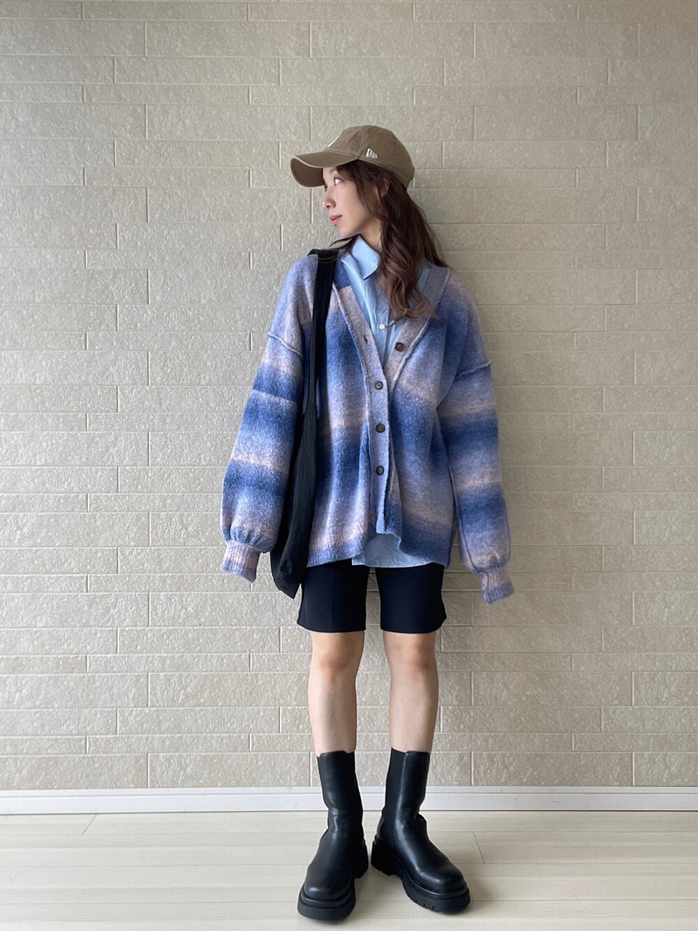 ブルー系のカーディガン/ボレロ、ブラック系のブーツ、ブラック系のその他パンツを着用したレディースの秋コーディネートの2枚目の写真