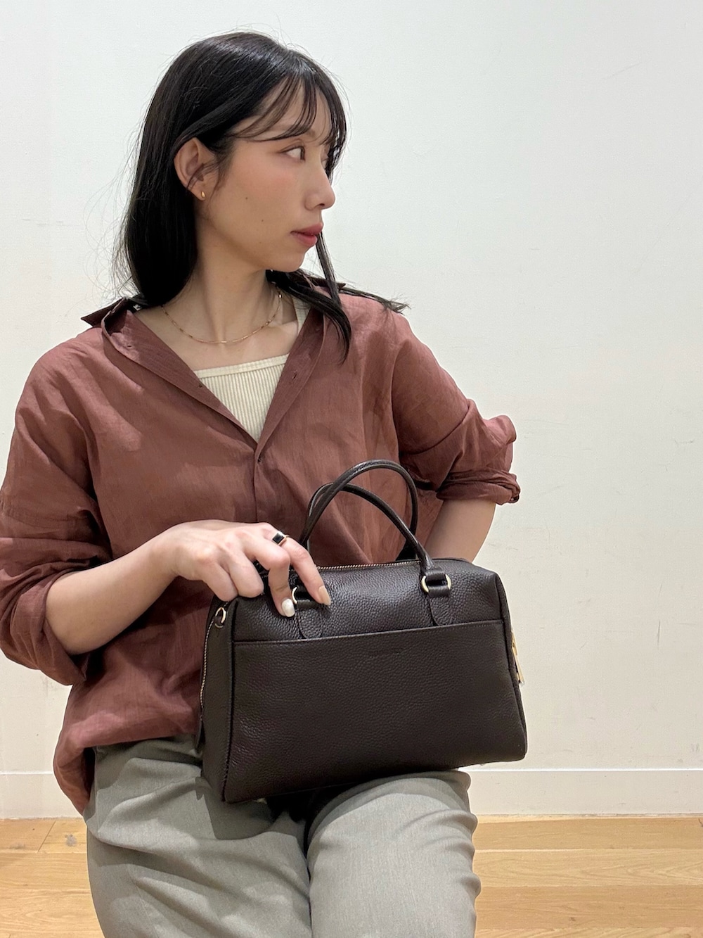 ブラウン系のサンダル、ブラウン系のボストンバッグ、ホワイト系のタンクトップを着用したレディースの春コーディネートの5枚目の写真