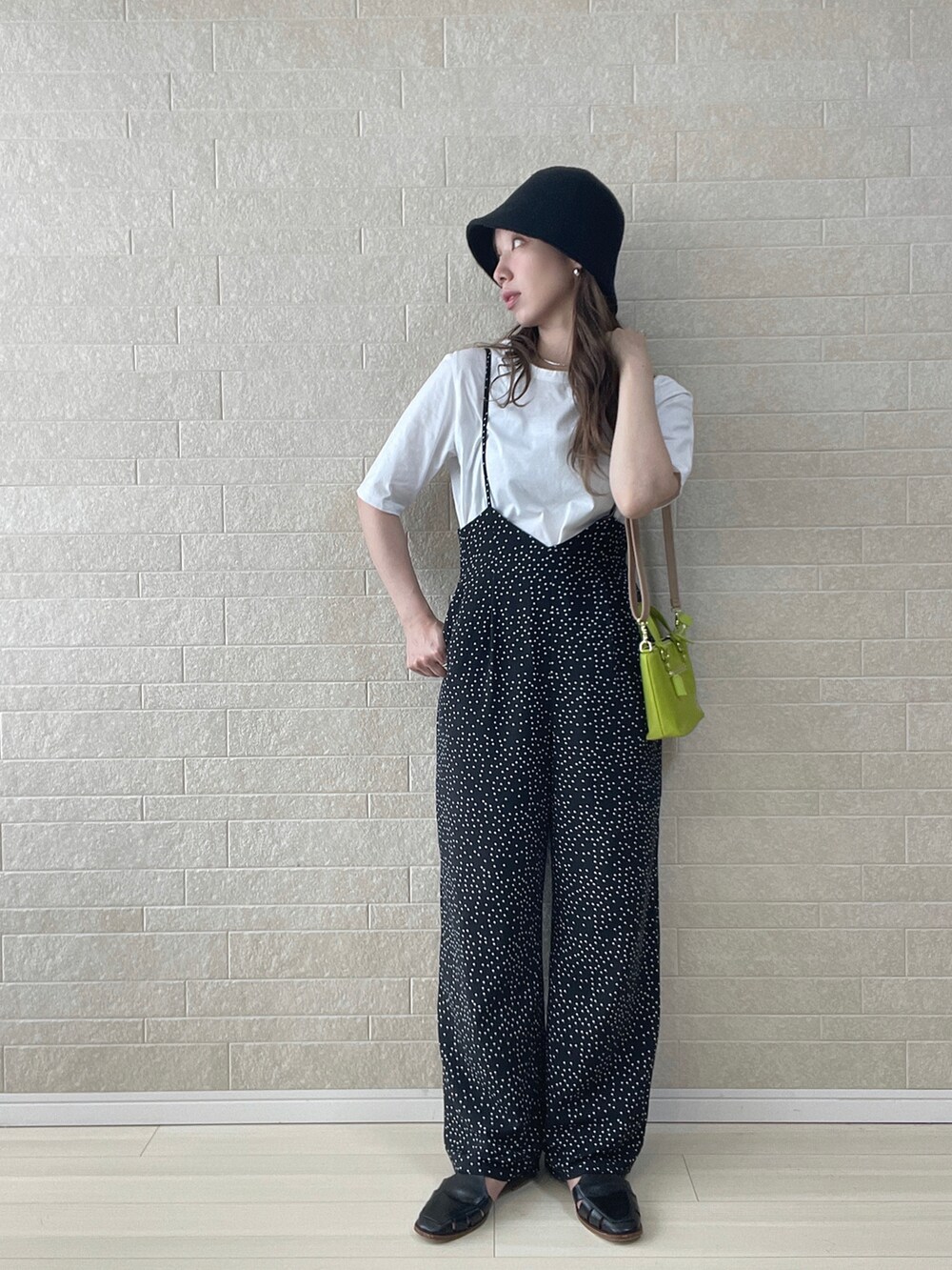 グリーン系のショルダーバッグ、ブラック系のサロペット/オーバーオール、ブラック系のサンダルを着用したレディースの夏コーディネートの3枚目の写真