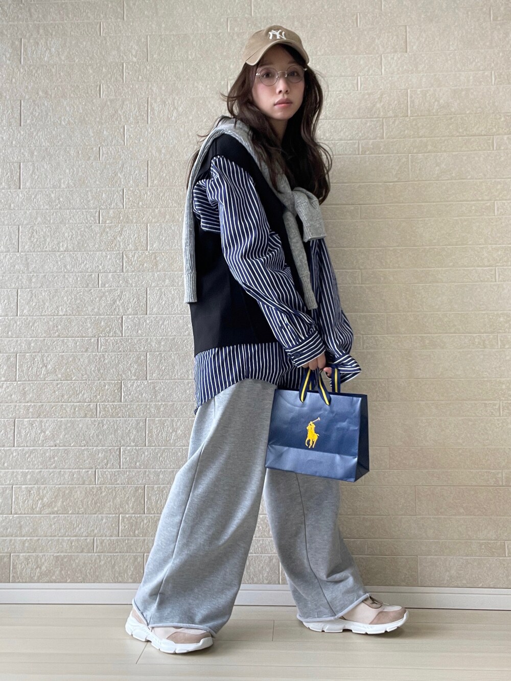 ピンク系のスニーカー、ブルー系のシャツ/ブラウス、ブラック系のベストを着用したレディースの冬コーディネートの2枚目の写真