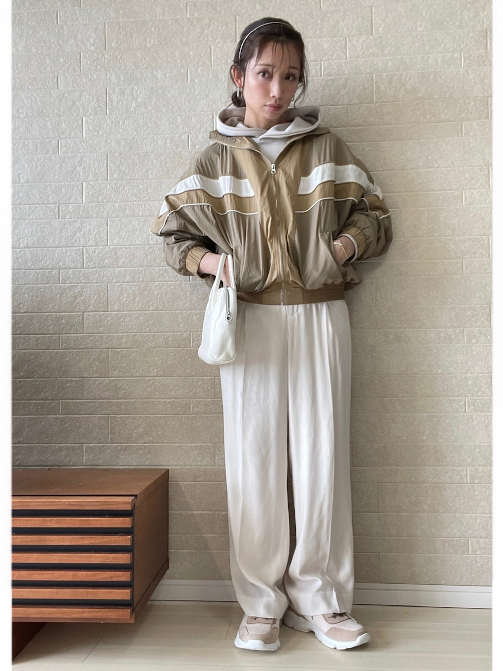 ピンク系のスニーカー、ホワイト系のその他パンツ、ホワイト系のボストンバッグを着用したレディースの春コーディネートの2枚目の写真