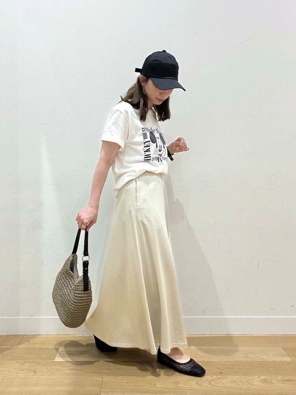 グレー系のトートバッグ、イエロー系のサンダル、ホワイト系のTシャツ/カットソーを着用したレディースの夏コーディネートの3枚目の写真