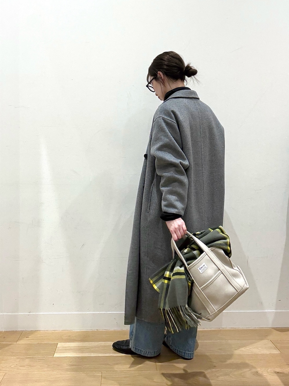 ホワイト系のシャツ/ブラウス、ブルー系のデニムパンツ、ベージュ系のトートバッグを着用したレディースの冬コーディネートの4枚目の写真