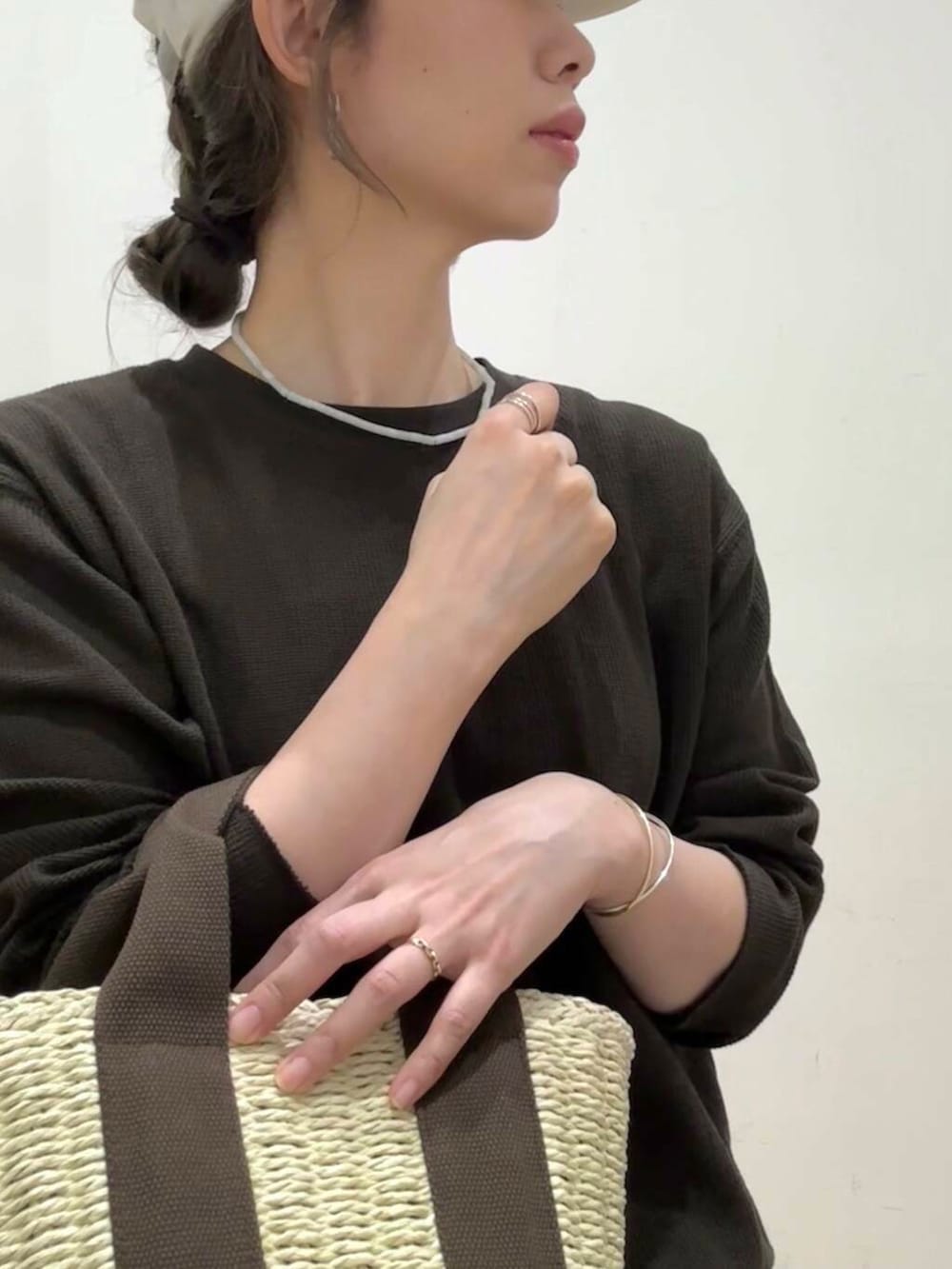 ホワイト系のハンドバッグ、グレー系のパンプス、ブラウン系のTシャツ/カットソーを着用したレディースの春コーディネートの6枚目の写真