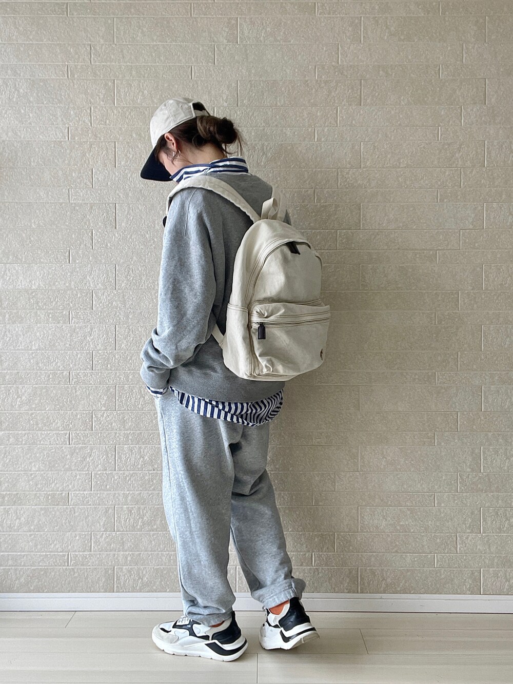 ホワイト系のバックパック/リュック、ブルー系のシャツ/ブラウス、グレー系のスウェットパンツを着用したレディースの冬コーディネートの5枚目の写真