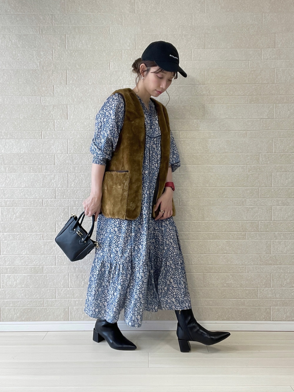 ブラック系のブーツ、グレー系のワンピース、ブラウン系のベストを着用したレディースの秋コーディネートの3枚目の写真
