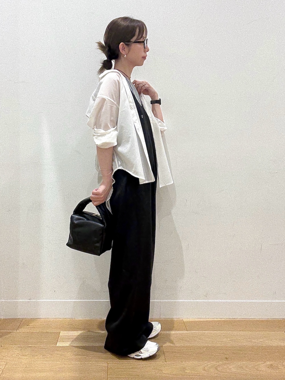 ブラック系のハンドバッグ、ブラック系のワンピース、グレー系のTシャツ/カットソーを着用したレディースの秋コーディネートの2枚目の写真