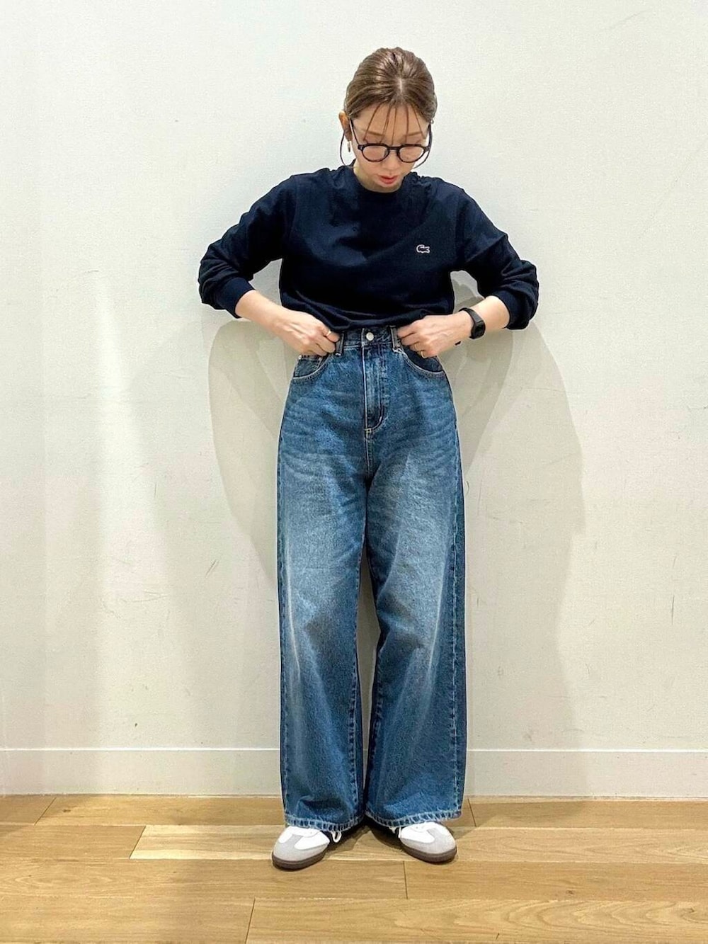 ブルー系のデニムパンツ、ホワイト系のスニーカー、グレー系のトートバッグを着用したレディースの秋コーディネートの5枚目の写真