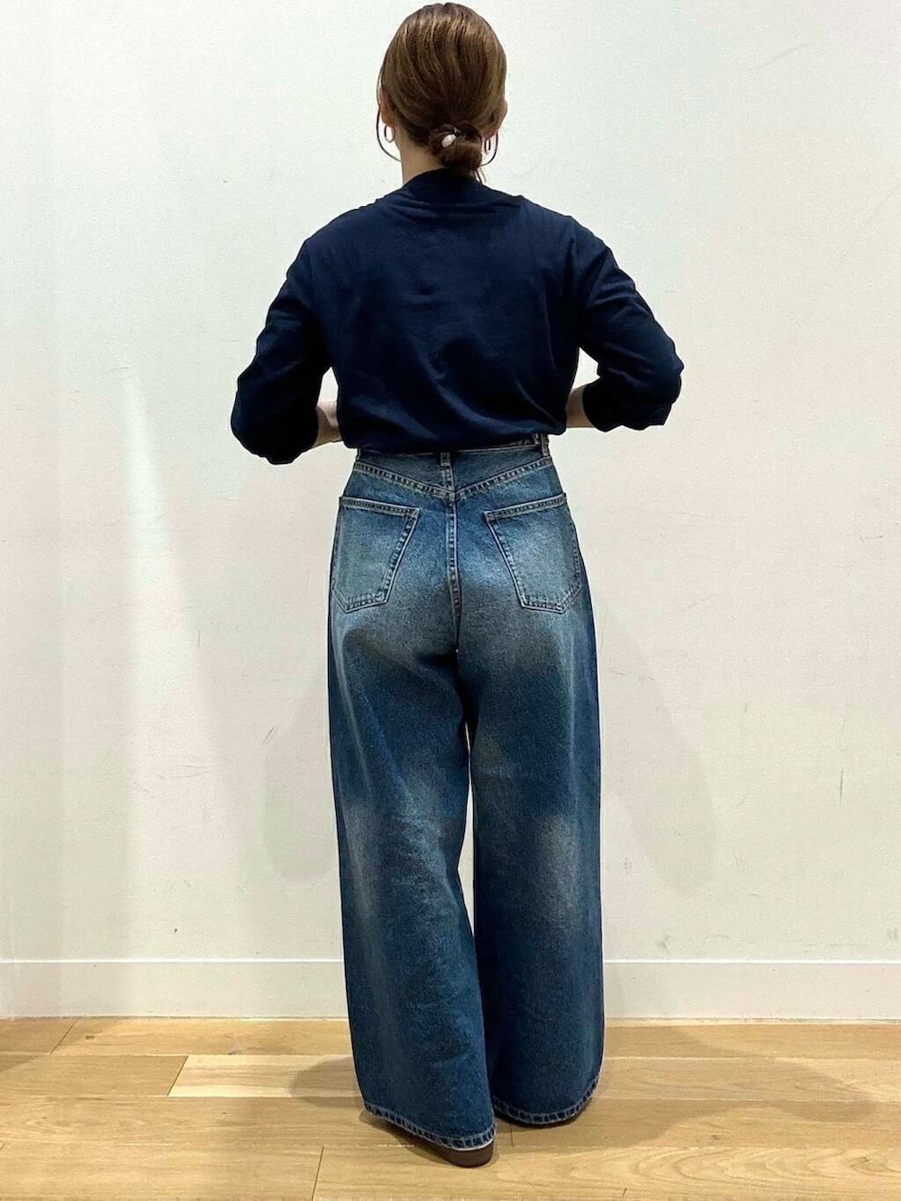 ブルー系のデニムパンツ、ホワイト系のスニーカー、グレー系のトートバッグを着用したレディースの秋コーディネートの6枚目の写真