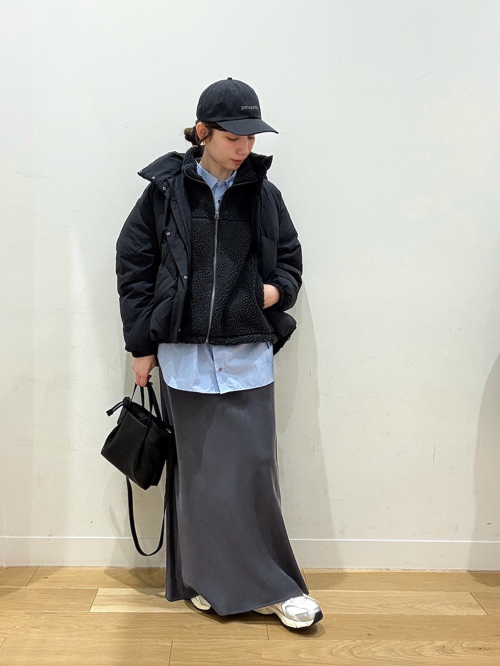 グレー系のベスト、ブラック系のダウンジャケット/コート、ブルー系のシャツ/ブラウスを着用したレディースの冬コーディネートの4枚目の写真