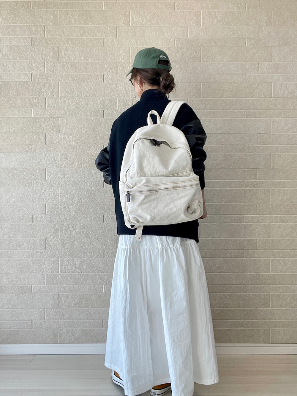 ホワイト系のバックパック/リュック、ブラック系のスタジャン、ホワイト系のワンピースを着用したレディースの冬コーディネートの4枚目の写真