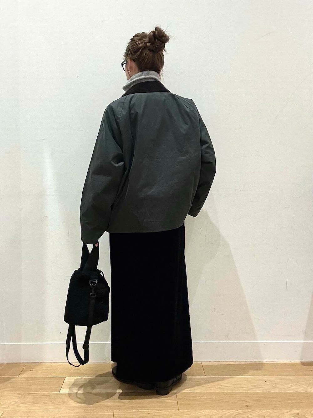 ブラック系のブーツ、グレー系のカーディガン/ボレロ、ブラック系のスカートを着用したレディースの冬コーディネートの3枚目の写真