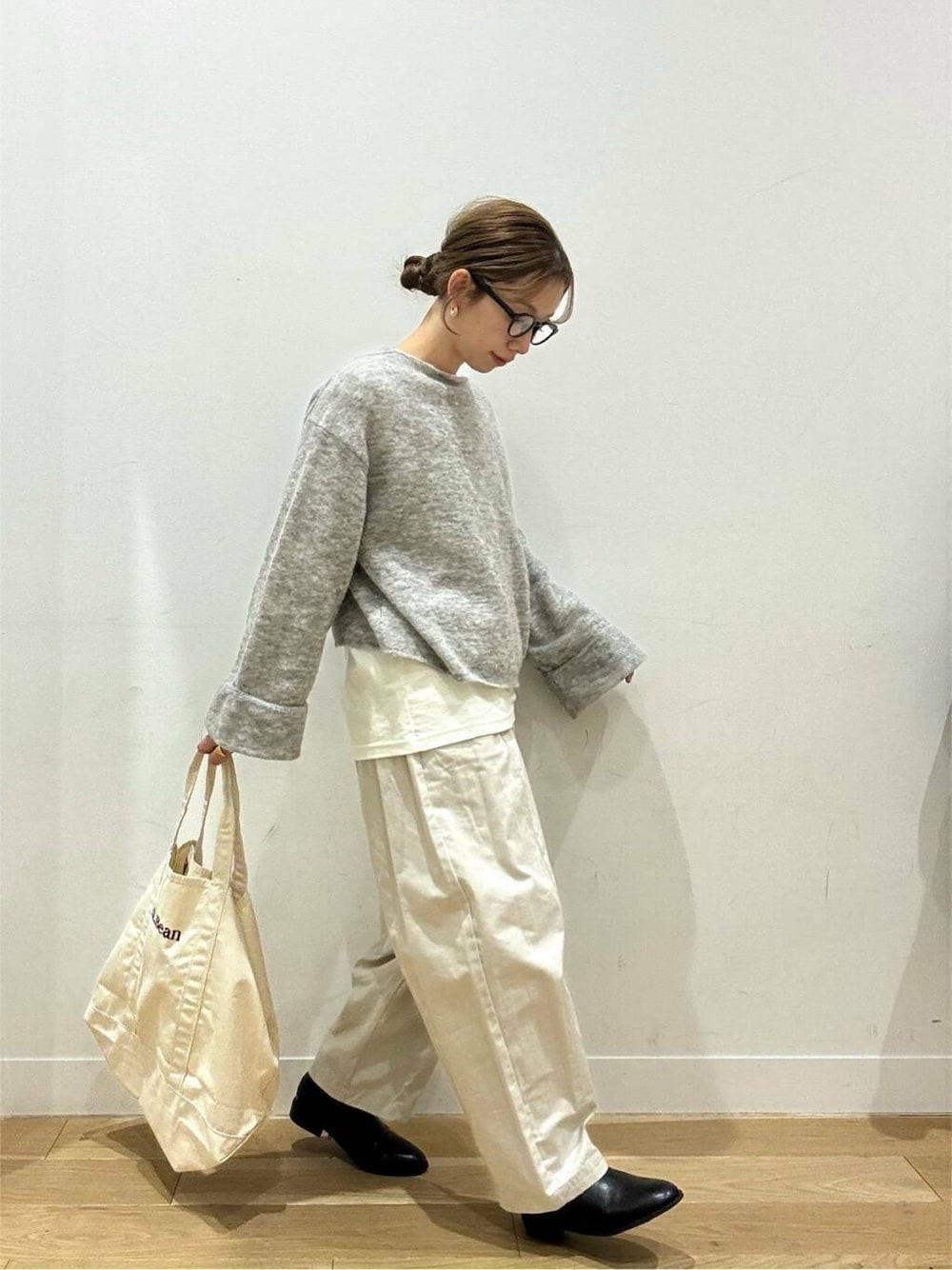 ホワイト系のトートバッグ、ベージュ系のデニムパンツ、ブラック系のブーツを着用したレディースの冬コーディネートの9枚目の写真