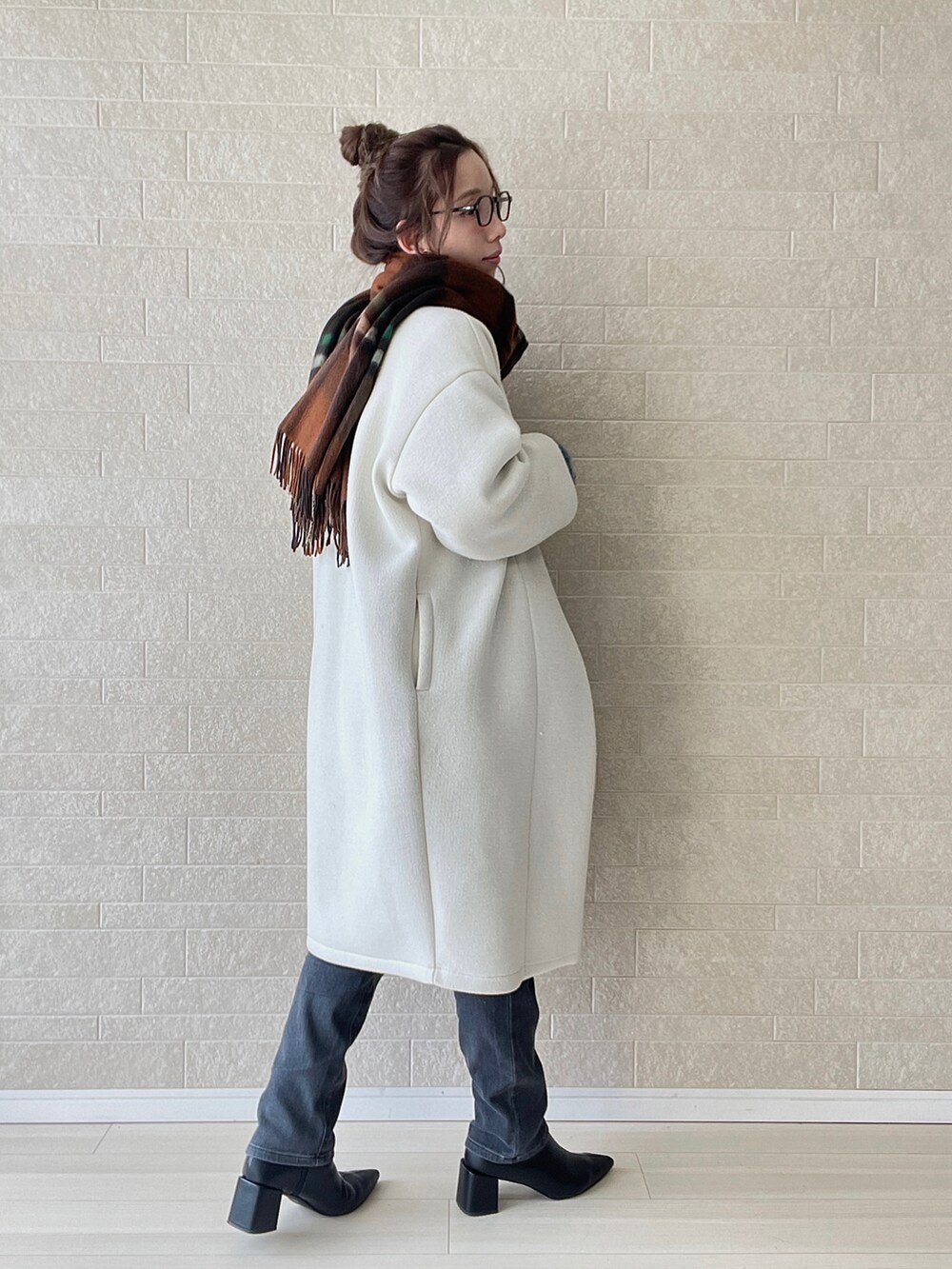 グレー系のデニムパンツ、ブラック系のブーツ、ブルー系のニット/セーターを着用したレディースの冬コーディネートの5枚目の写真