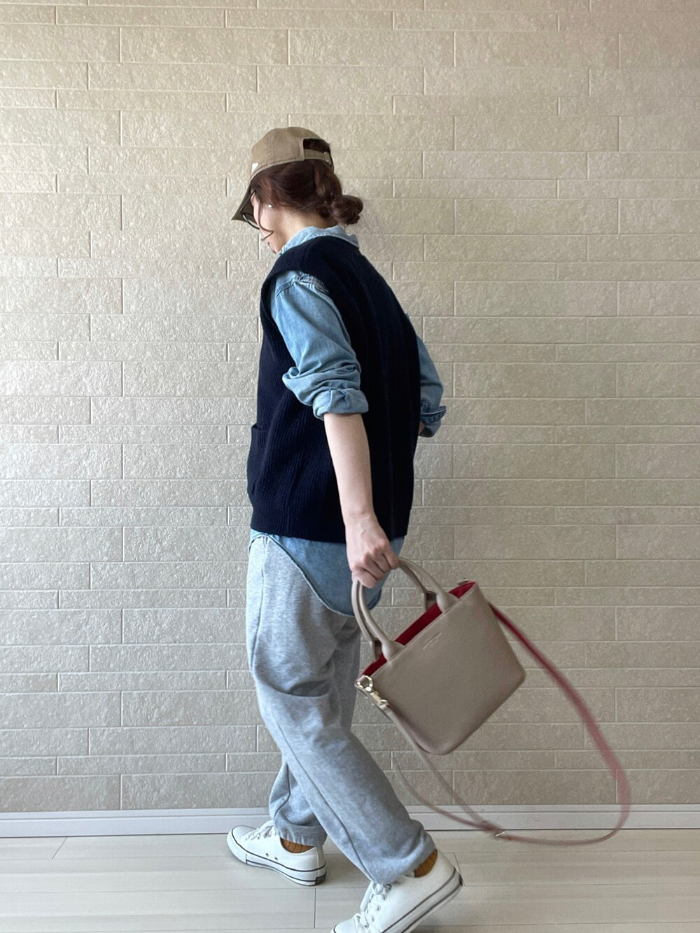 ベージュ系のトートバッグ、ブルー系のベスト、ブルー系のシャツ/ブラウスを着用したレディースの春コーディネートの3枚目の写真