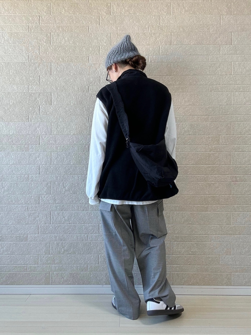 ブラック系のショルダーバッグ、ホワイト系のTシャツ/カットソー、ブラック系のベストを着用したレディースの秋コーディネートの3枚目の写真