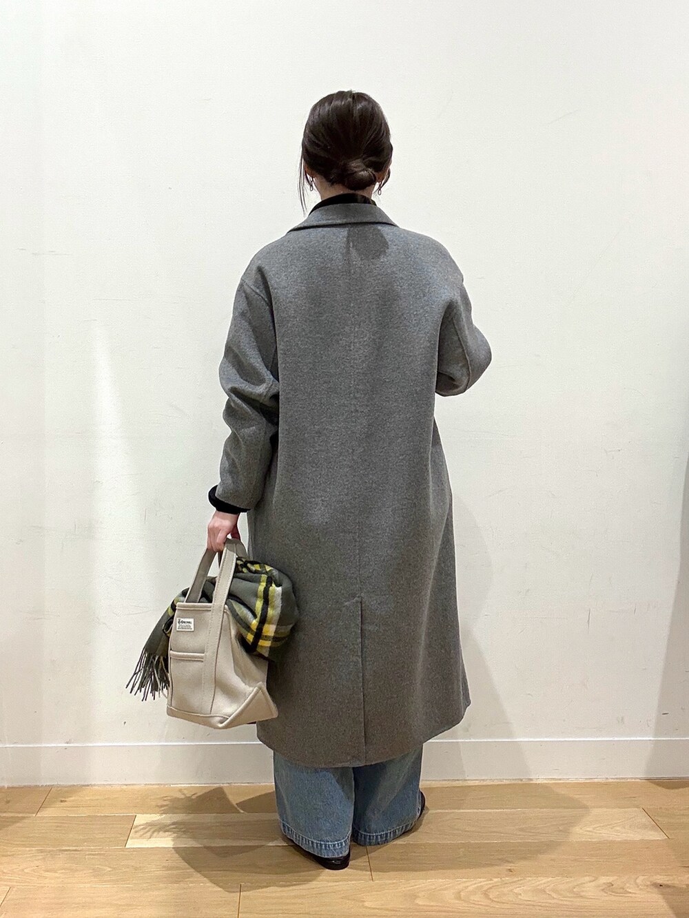 ホワイト系のシャツ/ブラウス、ブルー系のデニムパンツ、ベージュ系のトートバッグを着用したレディースの冬コーディネートの3枚目の写真