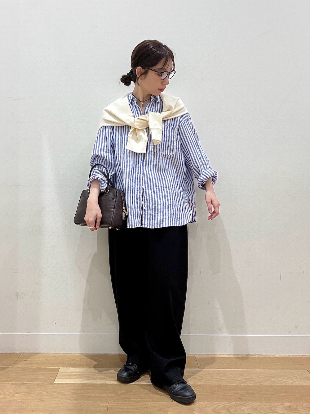 ホワイト系のブルゾン、ブラウン系のボストンバッグ、ブラック系のその他パンツを着用したレディースの春コーディネートの2枚目の写真