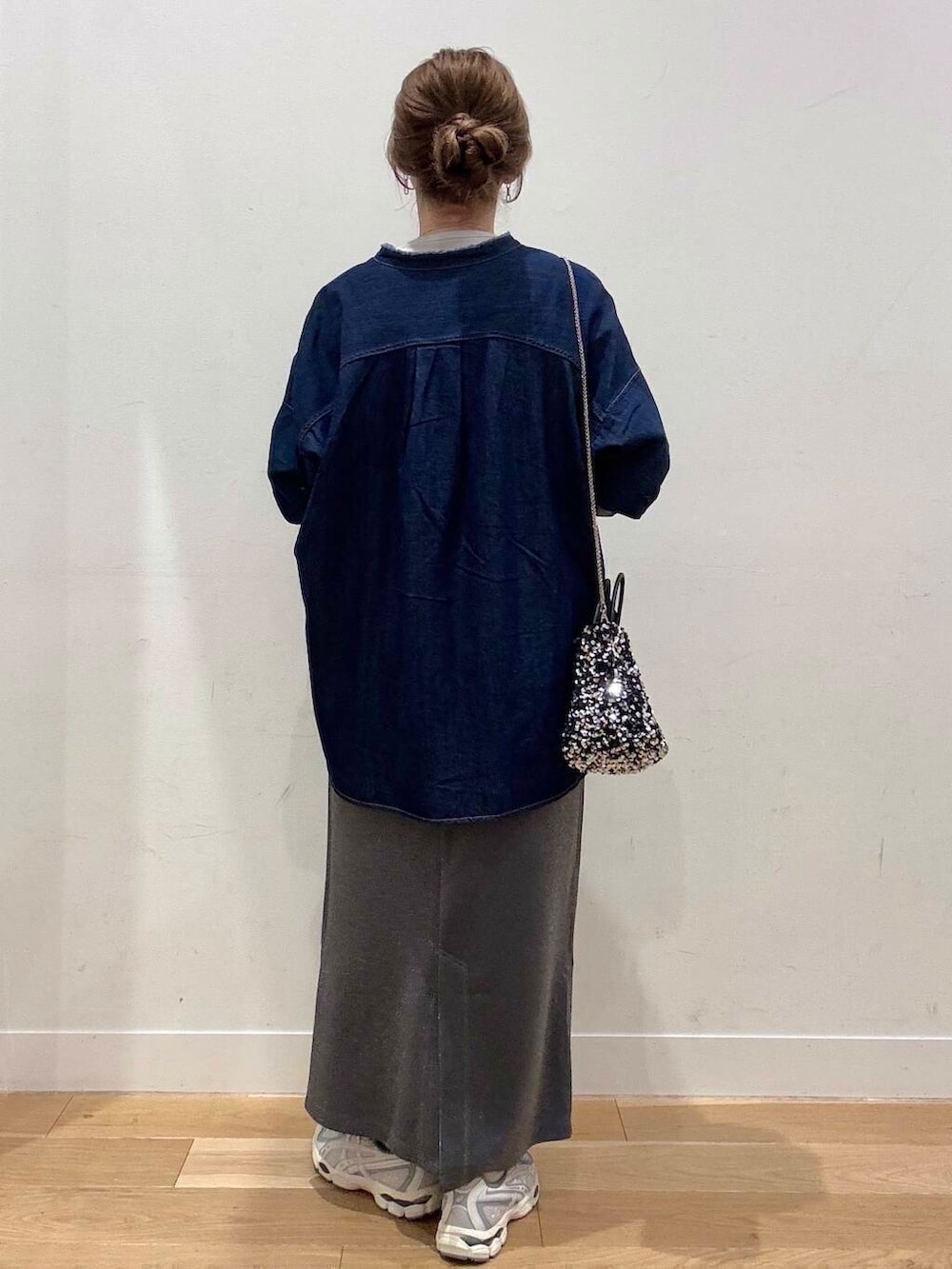 シルバー系のショルダーバッグ、グレー系のスカート、グレー系のTシャツ/カットソーを着用したレディースの冬コーディネートの4枚目の写真