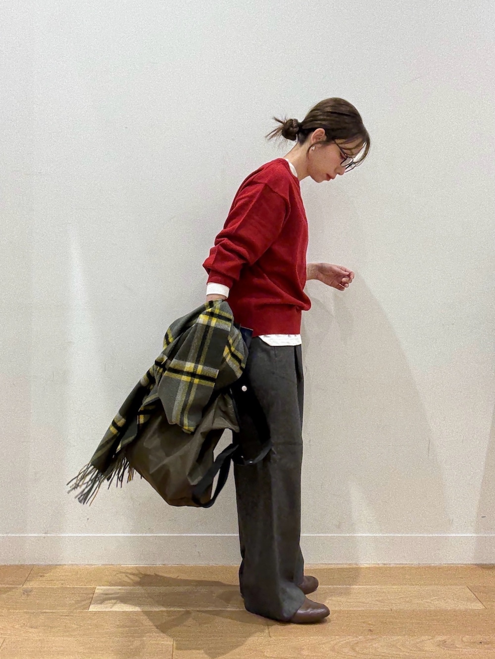 レッド系のニット/セーター、ブラック系のステンカラーコート、グリーン系のショルダーバッグを着用したレディースの秋コーディネートの2枚目の写真