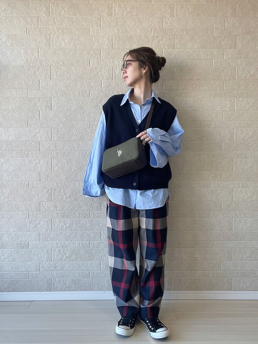 グリーン系のショルダーバッグ、ブルー系のその他パンツ、ブルー系のベストを着用したレディースの冬コーディネートの2枚目の写真