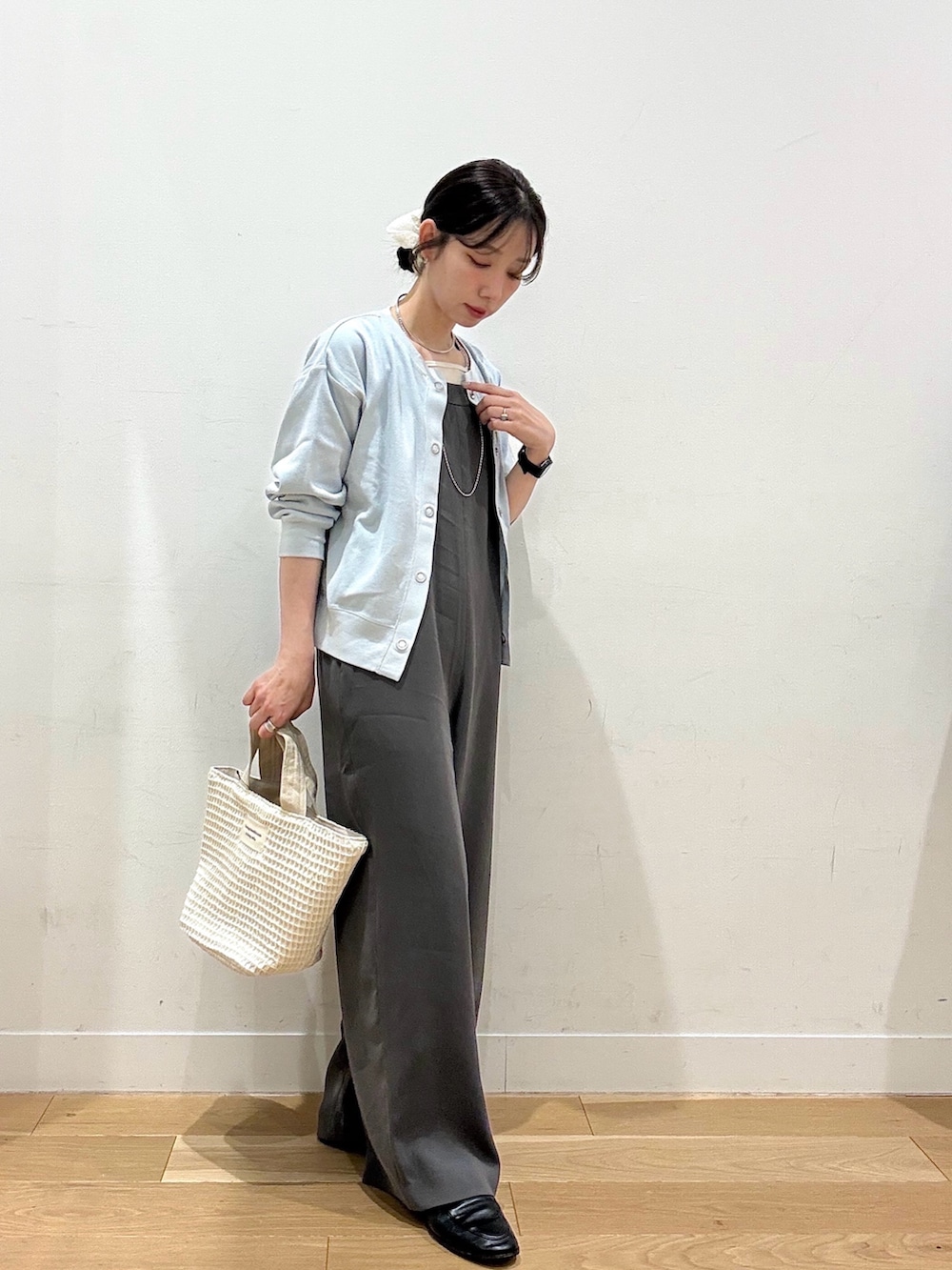 ホワイト系のトートバッグ、ブルー系のカーディガン/ボレロ、ホワイト系のタンクトップを着用したレディースの春コーディネートの4枚目の写真