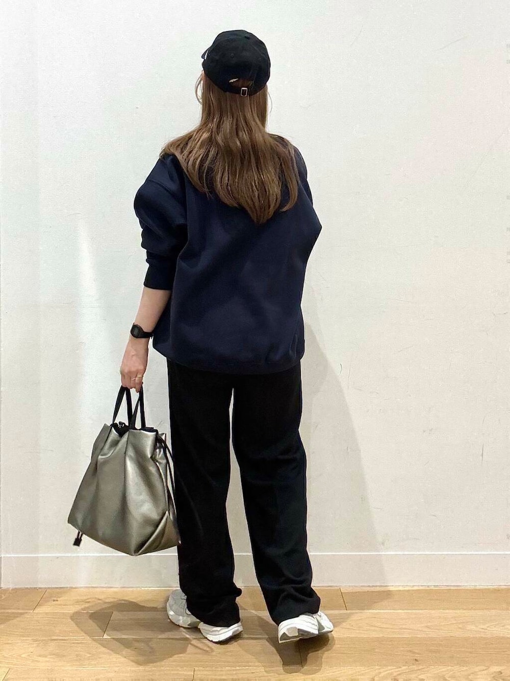 シルバー系のトートバッグ、シルバー系のスニーカー、ブルー系のスウェットを着用したレディースの冬コーディネートの4枚目の写真
