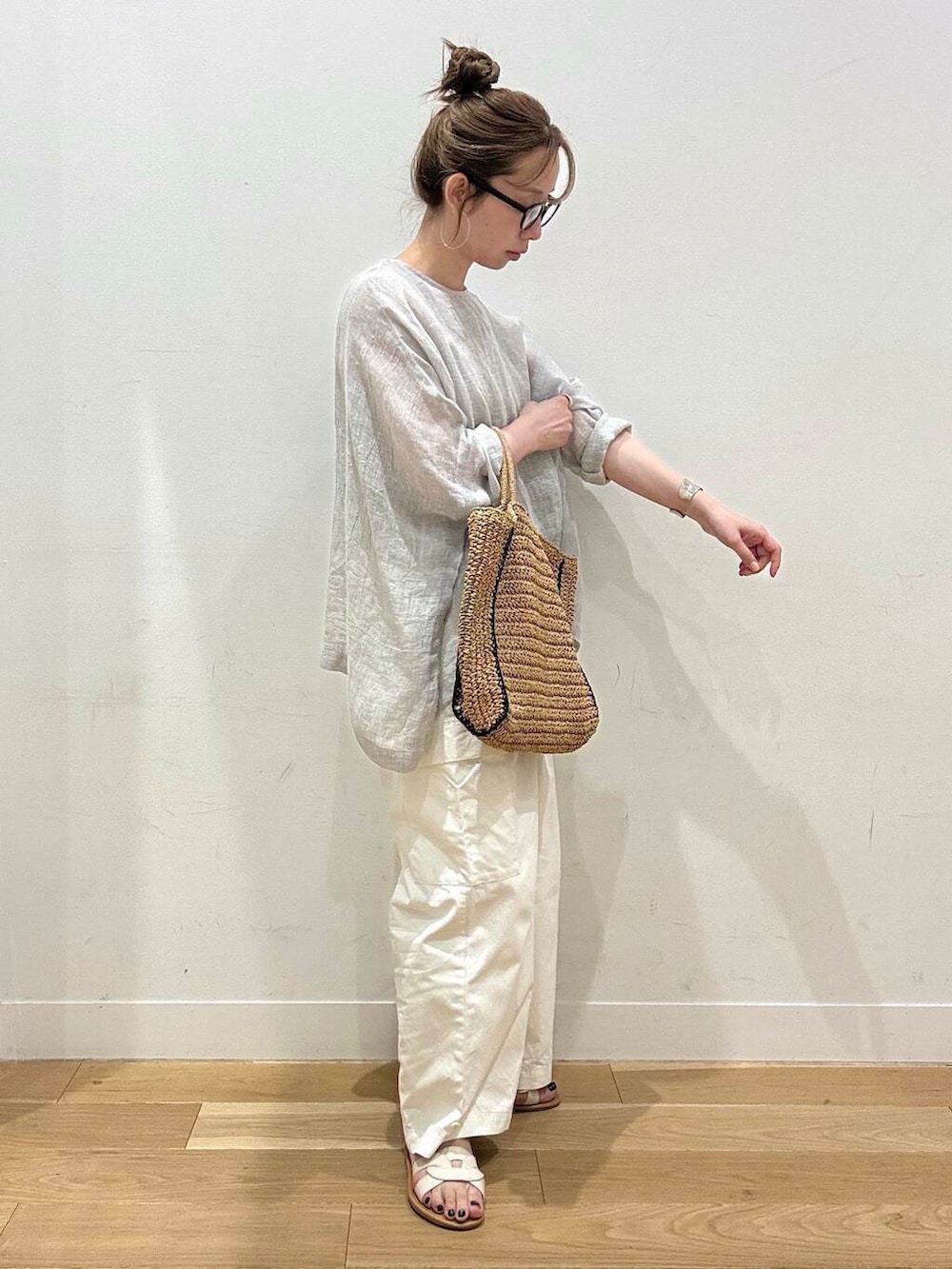 ベージュ系のトートバッグ、ホワイト系のサンダル、ベージュ系のタンクトップを着用したレディースの春コーディネートの3枚目の写真