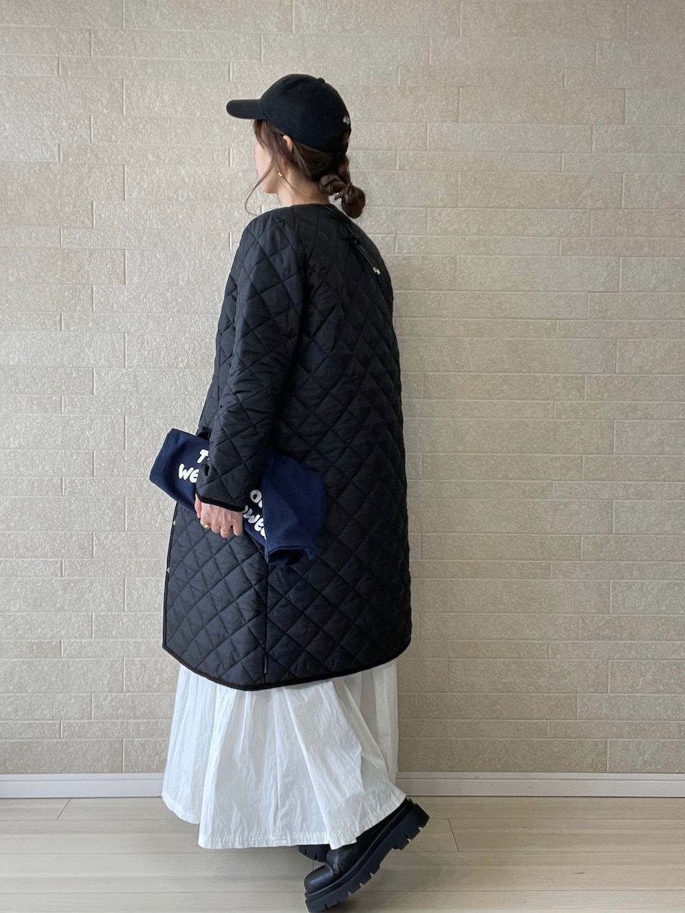 ブラック系のその他アウター、ブルー系のトートバッグ、ブラウン系のベストを着用したレディースの冬コーディネートの5枚目の写真