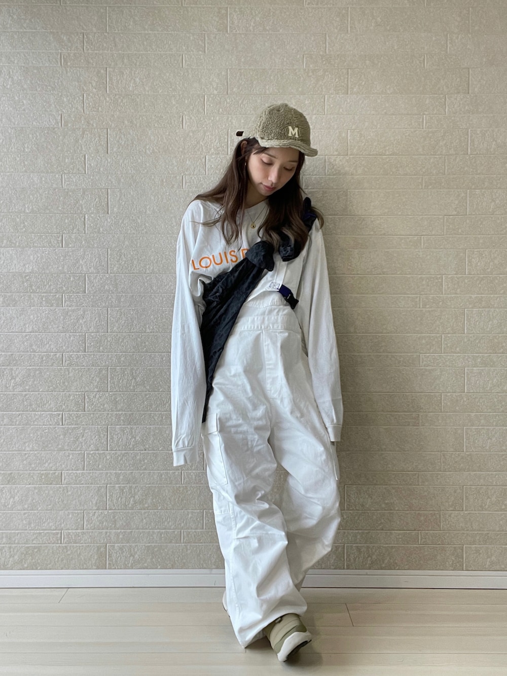 ホワイト系のサロペット/オーバーオール、ベージュ系のスニーカー、ブラック系のジャケット/アウターを着用したレディースの秋コーディネートの2枚目の写真