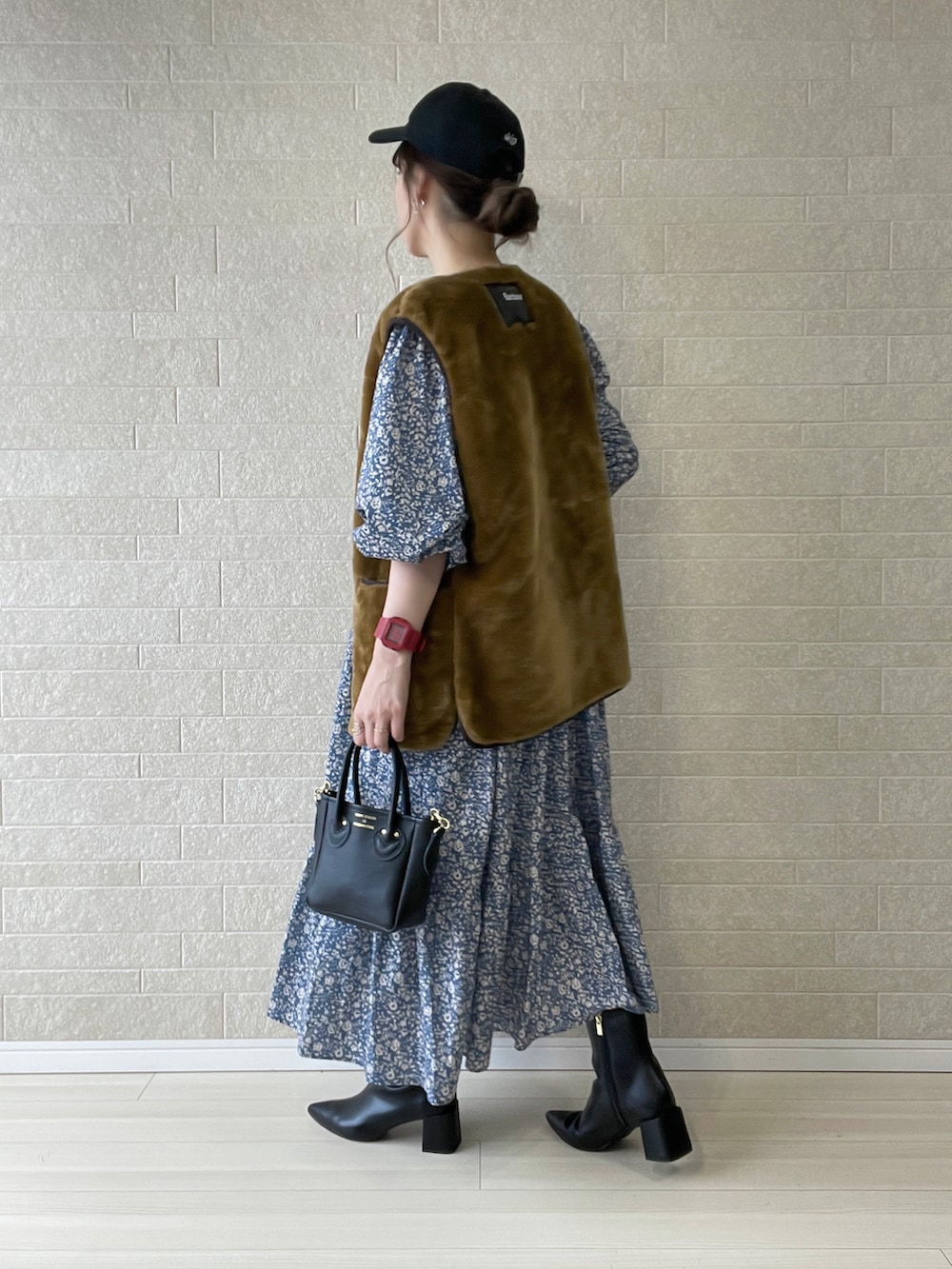 ブラック系のブーツ、グレー系のワンピース、ブラウン系のベストを着用したレディースの秋コーディネートの4枚目の写真