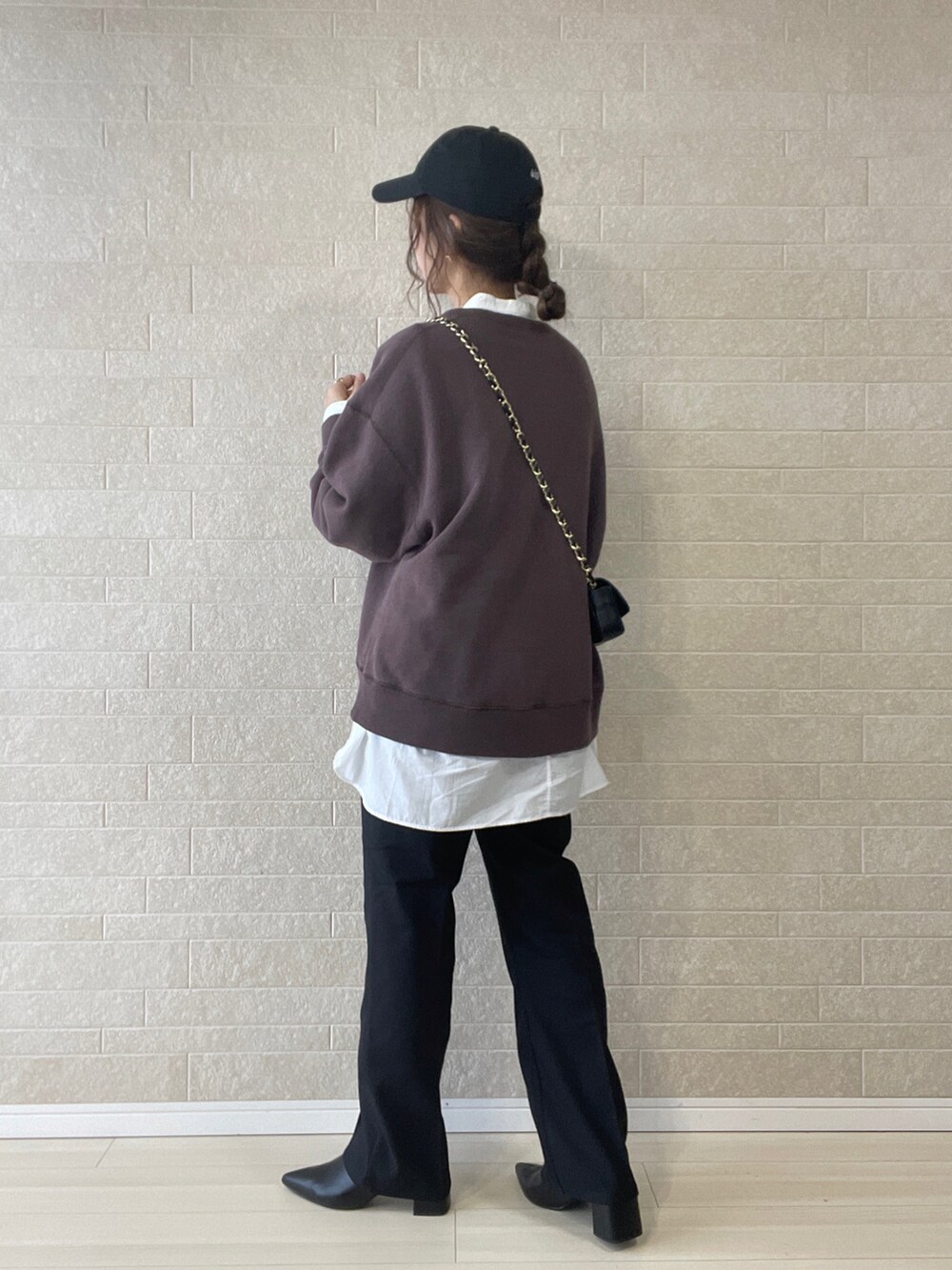 ブラック系のスラックス、ブラック系のブーツ、ブラウン系のスウェットを着用したレディースの秋コーディネートの3枚目の写真