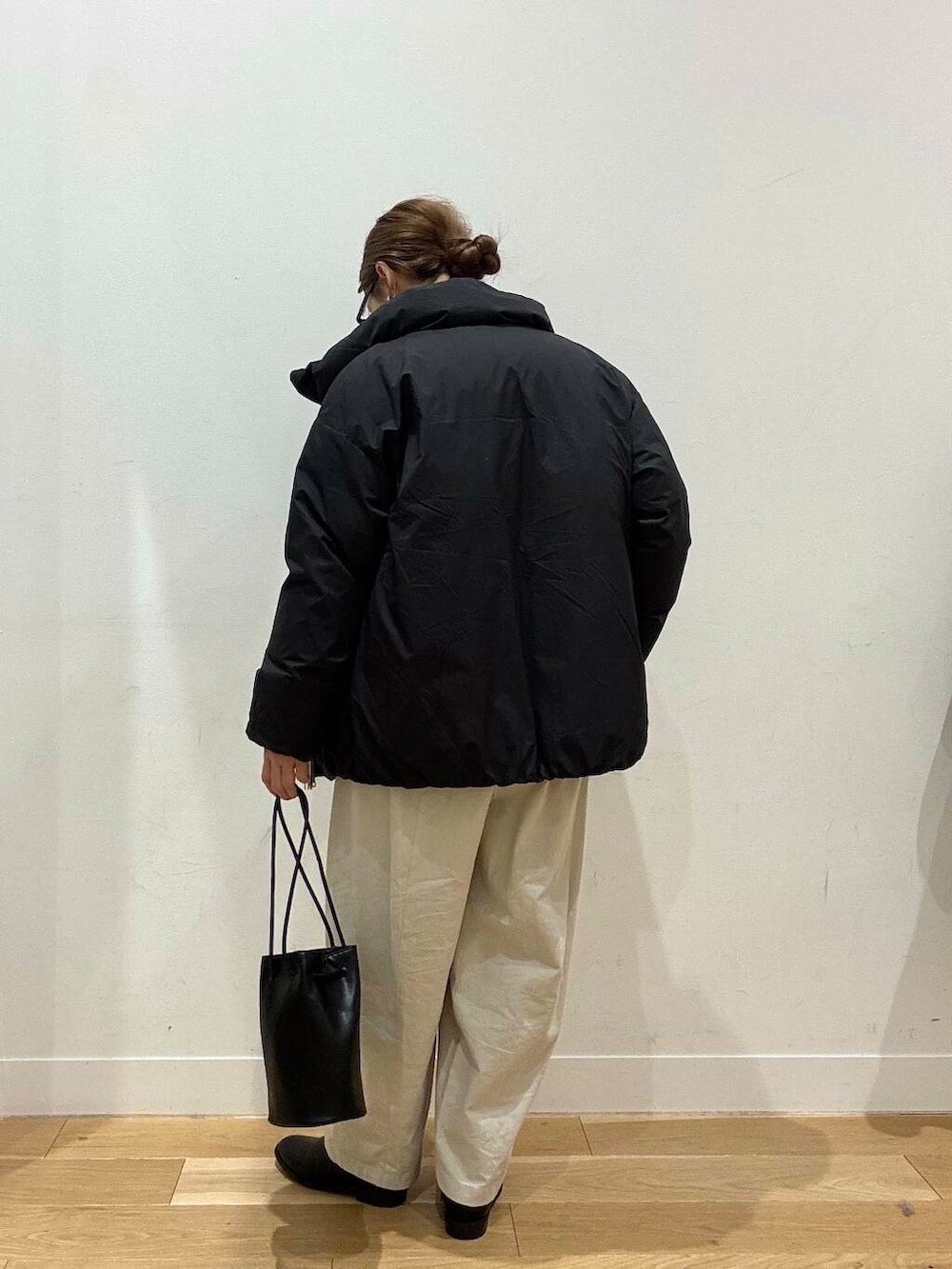 ホワイト系のトートバッグ、ベージュ系のデニムパンツ、ブラック系のブーツを着用したレディースの冬コーディネートの10枚目の写真