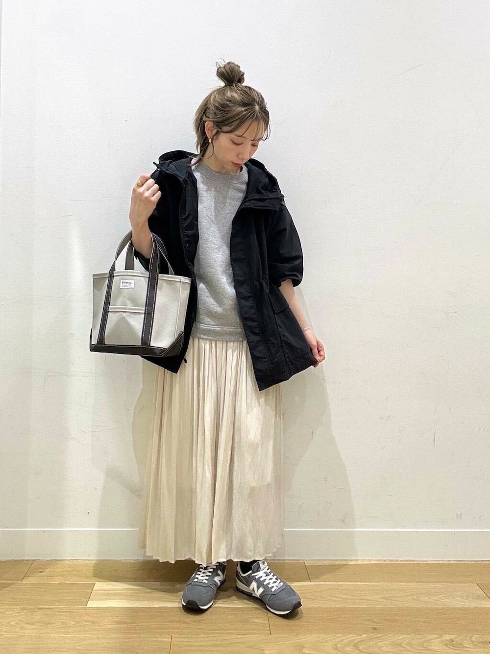 ブラック系のマウンテンパーカー、ホワイト系のスカート、グレー系のスウェットを着用したレディースの春コーディネートの4枚目の写真