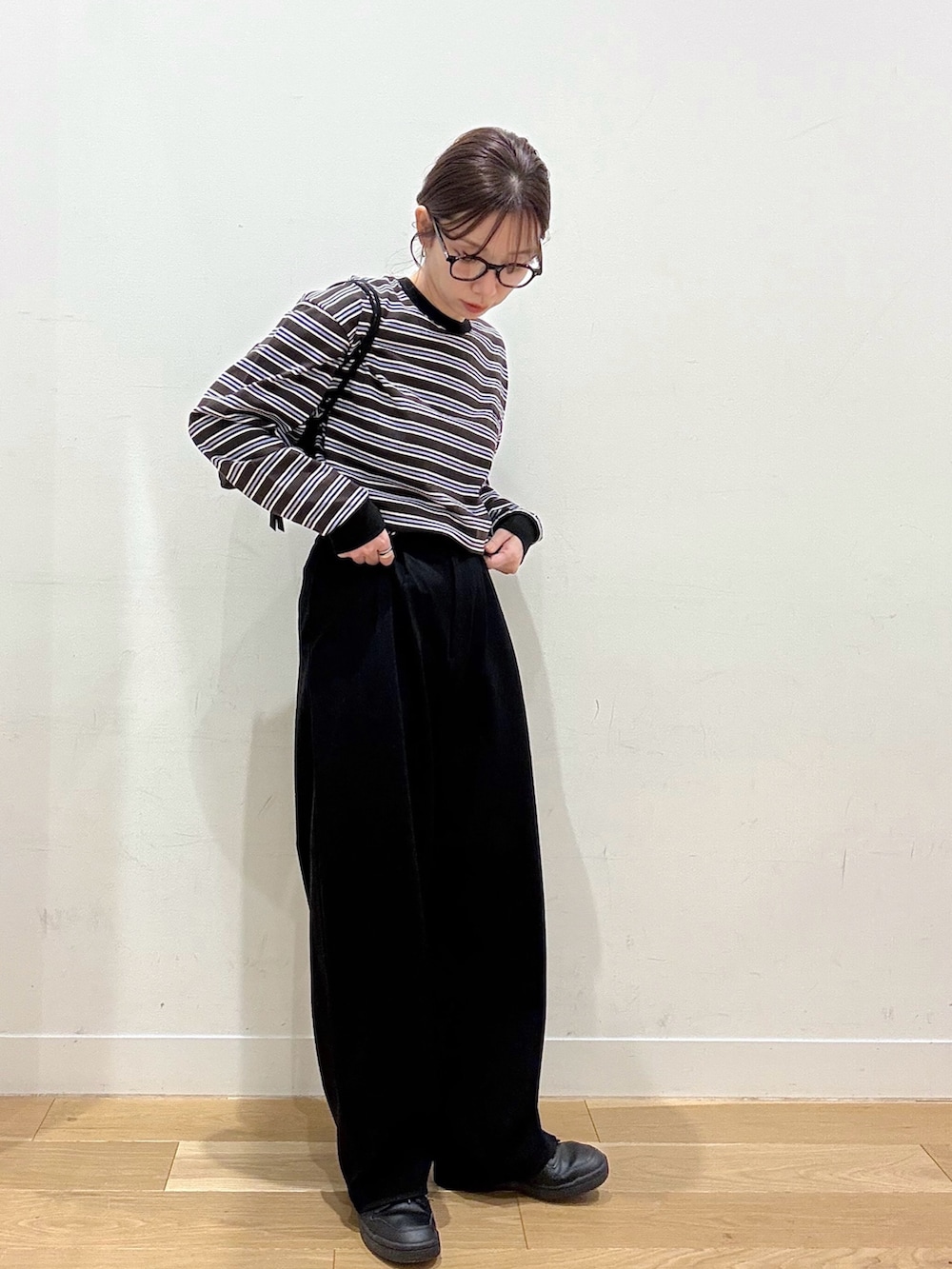 ブラウン系のTシャツ/カットソー、ベージュ系のステンカラーコート、ブラック系のその他パンツを着用したレディースの春コーディネートの3枚目の写真